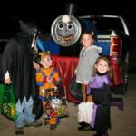 Photo courtesy B. Duncan who writes, "My little boy is a Thomas the Train fan so we decided to go with that theme. We created this out of some old plywood and a 55 gallon barrel. We cut a hole for the mouth of Thomas and put our bags of treats in there."  